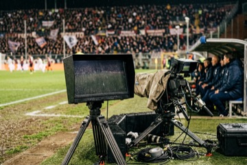 Monitor di regia a bordo campo con le immagini di una partita, senza loghi di squadra